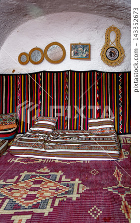 Interior View of Traditional Troglodyte Bedroom with Textured White Cave Walls and Folk Decor Interior View of Traditional Troglodyte Bedroom with Textured White Cave Walls and Folk Decor 143352673