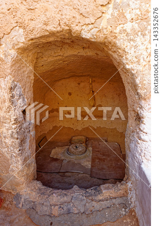 Traditional Stone Hand Mill Set Inside Arched Alcove of Berber Troglodyte Dwelling Traditional Stone Hand Mill Set Inside Arched Alcove of Berber Troglodyte Dwelling 143352676
