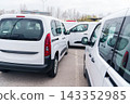 White delivery vans are parked in rows. Commercial fleet of vehicles 143352985