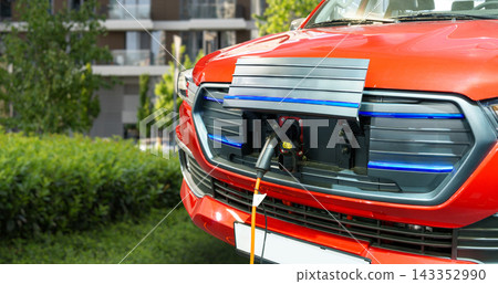 Close up of electric SUV car front inlet with a connected charging cable. Close up of electric SUV car front inlet with a connected charging cable. 143352990