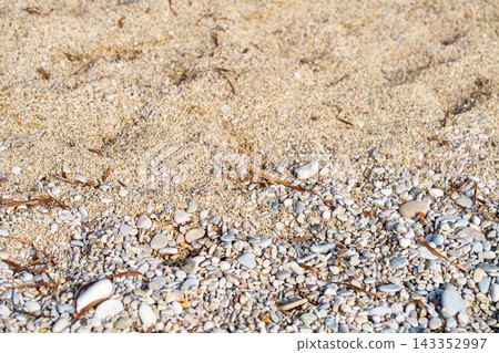 Close-up of sea sand and colorful pebbles on a beach. Close-up of sea sand and colorful pebbles on a beach. 143352997