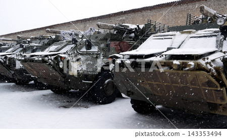 A lot of armored personnel carriers are standing near the hangars A lot of armored personnel carriers are standing near the hangars 143353494
