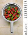 Close up of ripe strawberries soaking in water inside a colander.  143353548