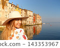 Charming young woman is posing in the quiet harbor of the town of Rovinj. Croatia. 143353967