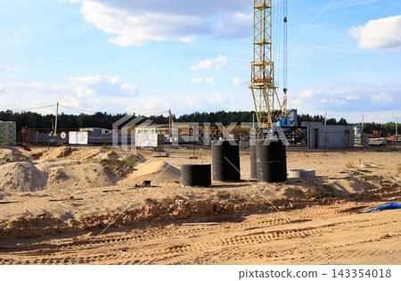 Yellow tower crane at a construction site. Use of heavy machinery and construction work. Yellow tower crane at a construction site. Use of heavy machinery and construction work. 143354018