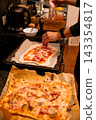 Adding ham slices to homemade pizza before baking 143354817