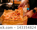 Removing freshly baked homemade pizza from the baking tray 143354824