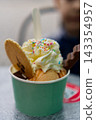 Ice cream in a paper cup with whipped cream and wafer 143354957