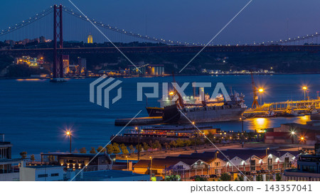 Skyline over Lisbon commercial port day to night timelapse, 25th April Bridge, containers on pier with freight cranes Skyline over Lisbon commercial port day to night timelapse, 25th April Bridge, containers on pier with freight cranes 143357041