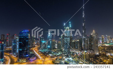 Dubai Downtown day to night timelapse. Aerial view over big futuristic city by night. Dubai Downtown day to night timelapse. Aerial view over big futuristic city by night. 143357141