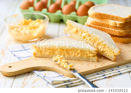 freshly made egg salad sandwiches on a white table, selective focus. freshly made egg salad sandwiches on a white table, selective focus. 143358512