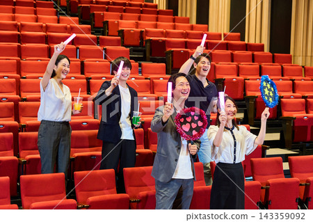 Fans standing up in the audience at the live venue, cheering and getting excited. Fans standing up in the audience at the live venue, cheering and getting excited. 143359092