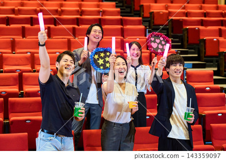 Fans standing up in the audience at the live venue, cheering and getting excited. Fans standing up in the audience at the live venue, cheering and getting excited. 143359097
