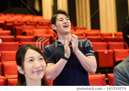 年輕人被某個事件或戲劇表演感動後鼓掌。 年輕人被某個事件或戲劇表演感動後鼓掌。 143359574