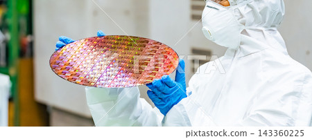 一名身穿防護服的女工在半導體工廠檢查矽片 143360225