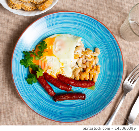 Delicious chistorra sausages with scrambled eggs and beans 143360399