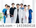 A medical team of Japanese doctors and nurses stands facing forward in a brightly lit hospital. 143360418