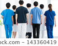 A team of medical staff, dressed in scrubs and white coats, walks away. 143360419