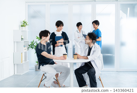 Medical staff chatting while drinking coffee in the break area. Medical staff chatting while drinking coffee in the break area. 143360421