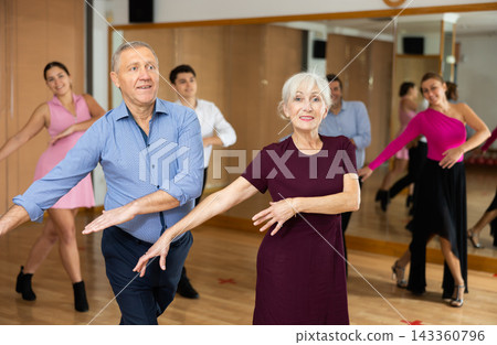 Couple of mature dancers rehearsing ballroom dances in dance studio Couple of mature dancers rehearsing ballroom dances in dance studio 143360796