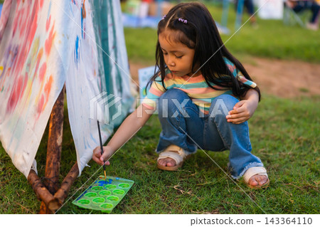 preschool child girl painting watercolors on canvas outdoors in park preschool child girl painting watercolors on canvas outdoors in park 143364110