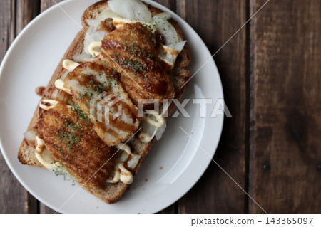 用全麥麵包做成的開放式三明治,裡面夾著洋蔥和炸丸子。 用全麥麵包做成的開放式三明治,裡面夾著洋蔥和炸丸子。 143365097