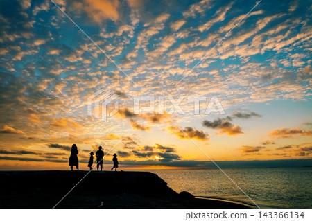 夕陽西下,宮古島海灘上,一家人站在一起,天空烏雲密布。 夕陽西下,宮古島海灘上,一家人站在一起,天空烏雲密布。 143366134