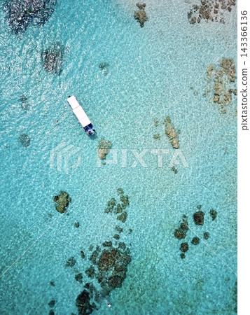 從高空拍攝的一艘小船在宮古島八重瀨清澈淺水中的照片。 143366136