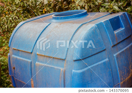 Blue Plastic Water Storage Tank in Rural Outdoor Setting Blue Plastic Water Storage Tank in Rural Outdoor Setting 143370095