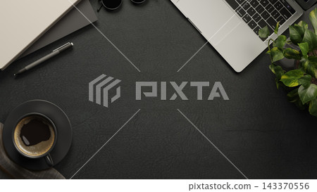 Overhead table with coffee cup, laptop, plant, pen, notebook and sunglasses on black leather surface Overhead table with coffee cup, laptop, plant, pen, notebook and sunglasses on black leather surface 143370556