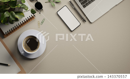 Top view of beige desk with blank smartphone, coffee cup, laptop, plant notebook and office supplies 143370557