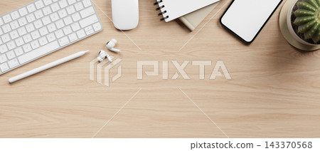 Top view of wooden working desk with keyboard, stylus, earbuds, notebook, smartphone and cactus pot. Top view of wooden working desk with keyboard, stylus, earbuds, notebook, smartphone and cactus pot. 143370568