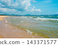 Sanya Hainan travel destination view. Sand beach, ocean waves, and cityscape on the horizon at summer day in Haitang Bay 143371577