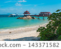 Tropical beach view with bridge, pagoda, rocks, and blue ocean on Pirate Island Wuzhizhou in Sanya Hainan. Summer travel destination 143371582