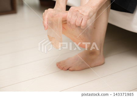 一位日本老婦人正在穿長襪,露出雙腳,穿好衣服,準備出門(沒有露臉)。 一位日本老婦人正在穿長襪,露出雙腳,穿好衣服,準備出門(沒有露臉)。 143371985