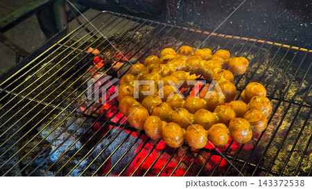 Thai Northeastern sausage grilled on a charcoal stove Thai Northeastern sausage grilled on a charcoal stove 143372538