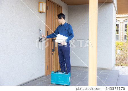 一名身穿工作服的男子正在檢查住宅設備。 一名身穿工作服的男子正在檢查住宅設備。 143373170