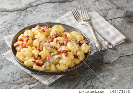rich and creamy gnocchi carbonara made with homemade pillowy gnocchi and tossed in an easy carbonara sauce with pancetta closeup on the plate. Horizontal rich and creamy gnocchi carbonara made with homemade pillowy gnocchi and tossed in an easy carbonara sauce with pancetta closeup on the plate. Horizontal 143373198