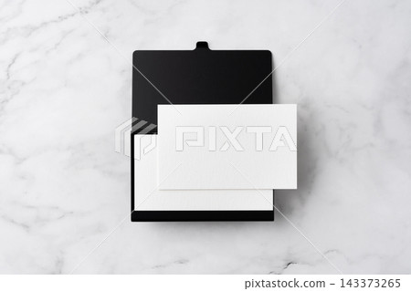 Blank white business cards and open black aluminum card holder on white marble background, top view flat lay with copy space Blank white business cards and open black aluminum card holder on white marble background, top view flat lay with copy space 143373265
