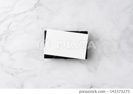 Blank white business cards and close black aluminum card holder on white marble background, top view flat lay with copy space Blank white business cards and close black aluminum card holder on white marble background, top view flat lay with copy space 143373275
