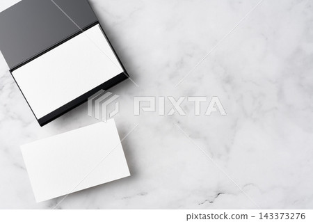 Blank white business cards and open black aluminum card holder on white marble background, top view flat lay with copy space Blank white business cards and open black aluminum card holder on white marble background, top view flat lay with copy space 143373276