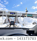 An ETC gate at the Shirakawa-go Interchange on a highway in a heavy snowfall area, and a snowy landscape (from the driver's perspective). 143373783