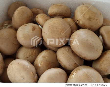 A lot of button mushrooms piled up. A lot of button mushrooms piled up. 143373877