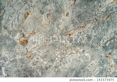 Gray Cracked Stone Texture with Orange Veins. Gray natural stone surface with irregular cracks, mineral patterns and warm orange veins. Detailed weathered stone texture for abstract background 143373975