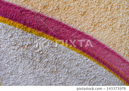 Colorful Curved Stripes on Rough Textured Wall. Painted wall with curved pink, yellow stripes on white and beige textured surface. Colorful abstract wall texture for backgrounds, graphic design 143373976