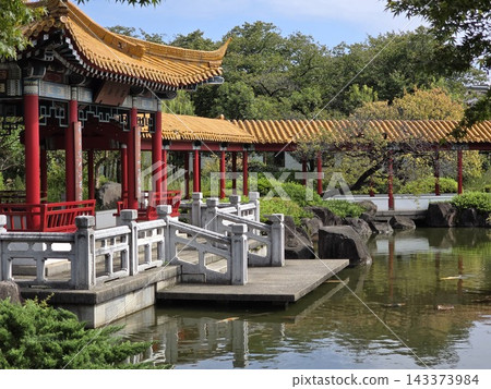 A beautiful stone bridge and pond reflect the scenery of a traditional Chinese garden with a gazebo and corridor. A beautiful stone bridge and pond reflect the scenery of a traditional Chinese garden with a gazebo and corridor. 143373984