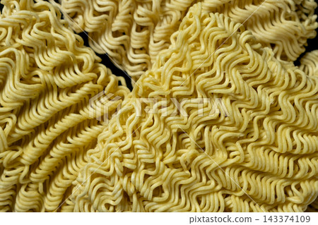 Uncooked instant ramen noodle blocks textured pattern close up Uncooked instant ramen noodle blocks textured pattern close up 143374109