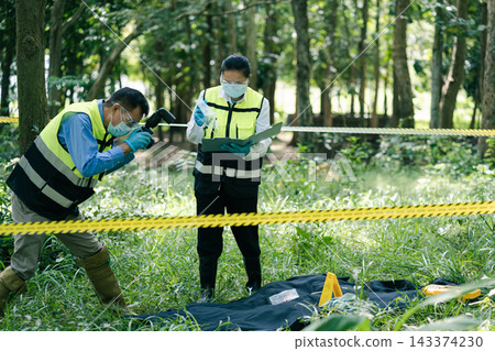 Investigator taking photo of evidence marker with camera at crime scene. 143374230