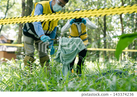 Investigator taking photo of evidence marker with camera at crime scene. Investigator taking photo of evidence marker with camera at crime scene. 143374236