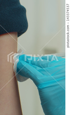 Vertical video. Child receiving vaccination at home from doctor. 143374537